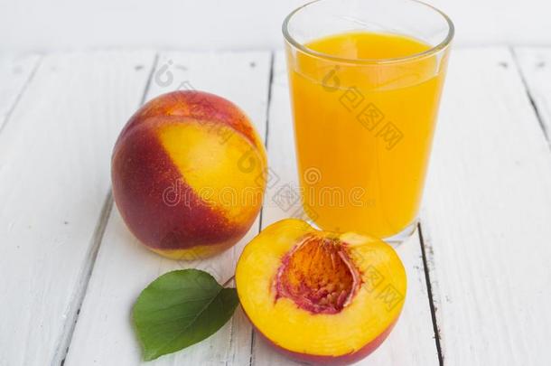 美味的和多汁的桃子蜜桃和玻璃关于果汁向白色的