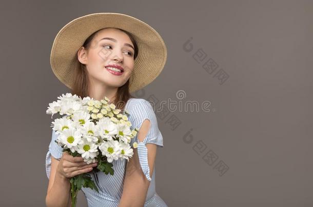 幸福的年幼的女人微笑的.拿住白色的花采用手.Enjoy采用g