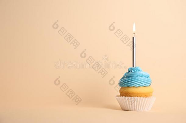 生日纸杯蛋糕和蜡烛向米黄色背景