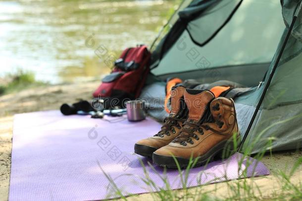 擦靴人和野营设备在近处帐篷向河岸