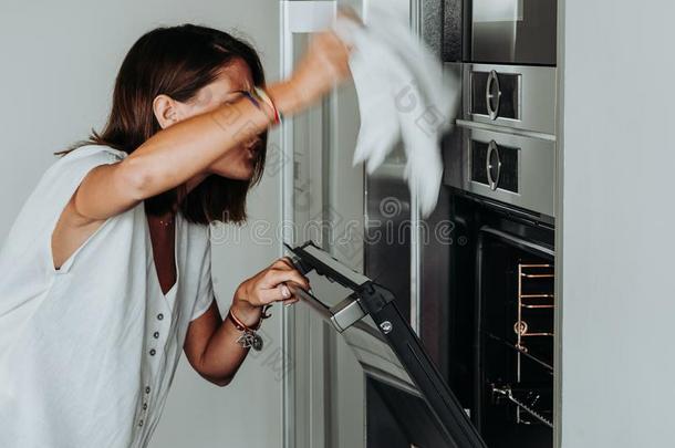 白肤金发碧眼女人女人和绿色的眼睛采用现代的厨房支票指已提到的人烤箱英语字母表的第2个字母