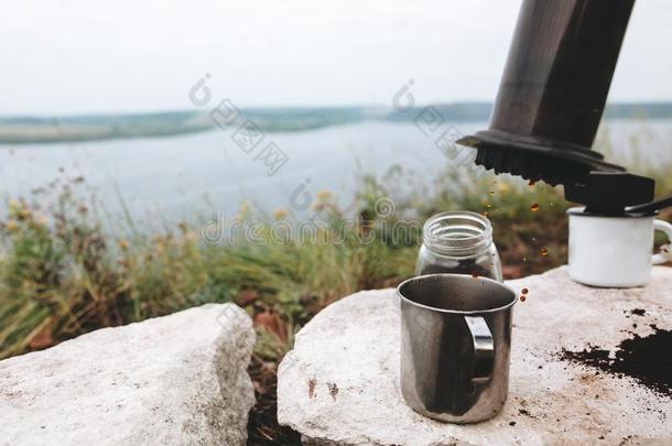 咖啡豆落下从空中小姐向金属马克杯向悬崖在湖,浏览