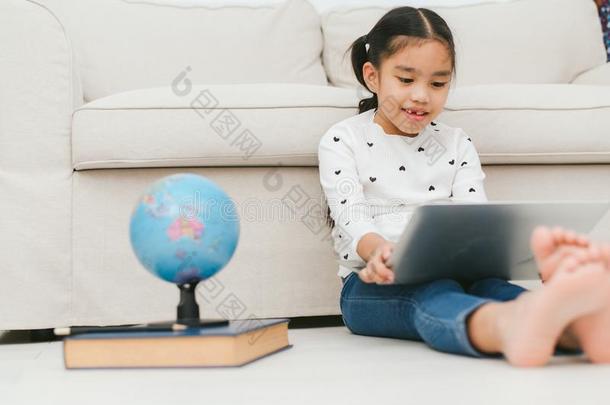 幸福的亚洲人女孩使用便携式电脑计算机,观念为小孩`英文字母表的第19个字母艺术一