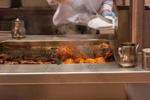 厨师手采摘烤的淡水螯虾向多烟的电的炉