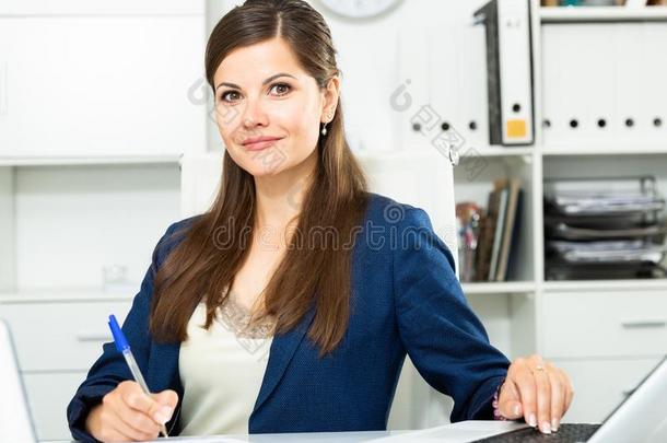成熟的商业女人使用便携式电脑在工作场所