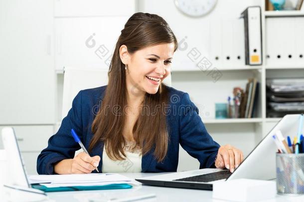 女人工作的和文件和便携式电脑采用办公室