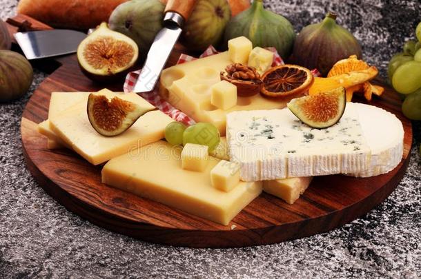 奶酪大浅盘和不同的奶酪和葡萄和figures数字和螺母