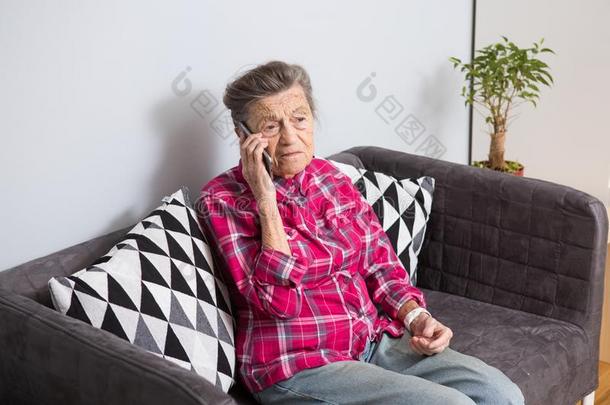 一老的上了年纪的女<strong>人</strong>祖母和灰色头发坐在家向