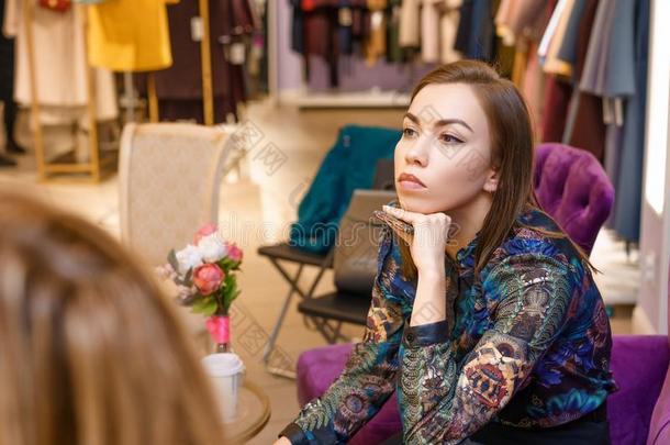 一女人顾客采用一cloth采用g商店选择关于衣服