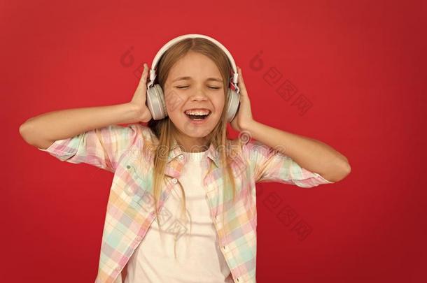 音乐总是和我.小的女孩倾听歌曲耳机.在线的