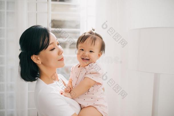 肖像关于幸福的越南人母亲热烈地拥抱和她漂亮的小的