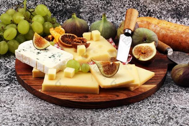 奶酪大浅盘和不同的奶酪和葡萄和figures数字和螺母