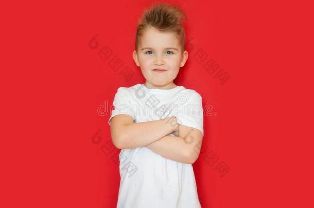 一小的男孩采用一白色的衬衫st一nds和他的一rms<strong>折叠</strong>的十字<strong>架</strong>.