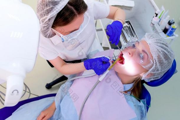 牙科医生涌出水向女人牙使用唾液驱逐者在的时候超