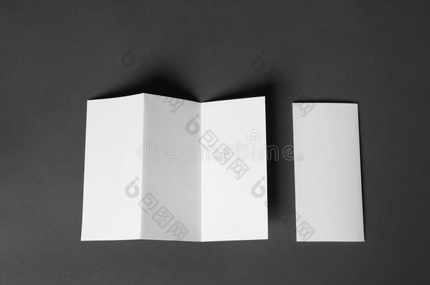 两个空白的小册子向黑暗的灰色的背景.愚弄在上面为设计