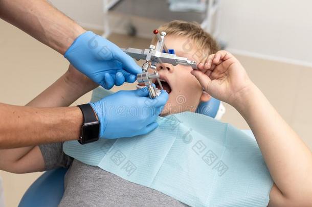 小的男孩打赌向椅子在期间牙科医生固定在上面orthod向tic综合症状