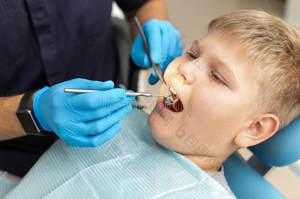 特写镜头关于年幼的男孩说谎向指已提到的人牙齿的椅子和是（be的三单形式存在考试