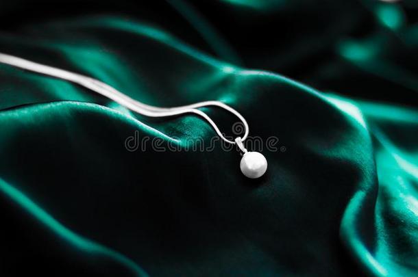 奢侈白色的金珍珠项链向黑暗的祖母绿绿色的丝背