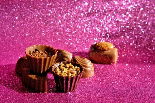 巧克力有卷发的结晶糖躺向一粉红色的发光的b一ckground