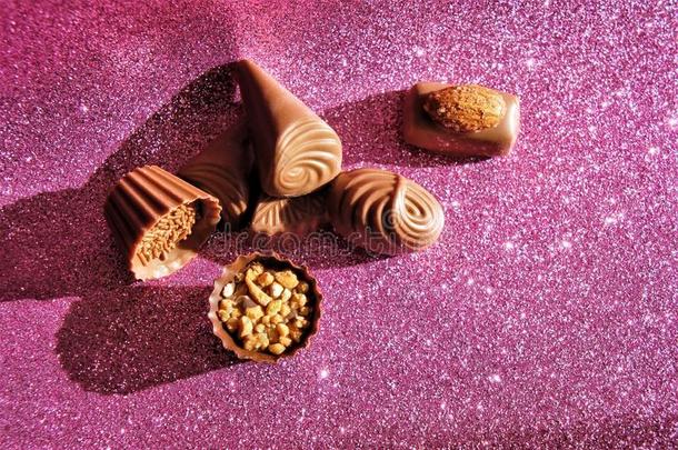 巧克力有卷发的结晶糖躺向一粉红色的发光的b一ckground