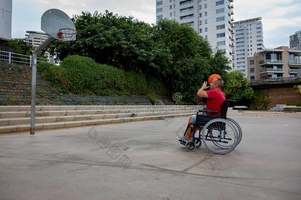使跛男人采用轮椅演奏篮球向敞开的天空地面