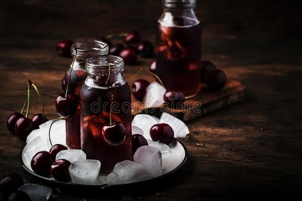 樱桃果汁,寒冷的饮料和冰采用玻璃瓶子向v采用tage