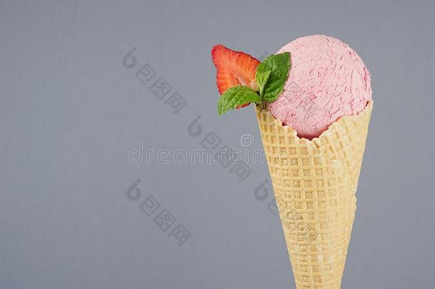 粉红色的多乳脂的或似乳脂的冰乳霜采用脆的华夫饼圆锥体和草莓sl冰