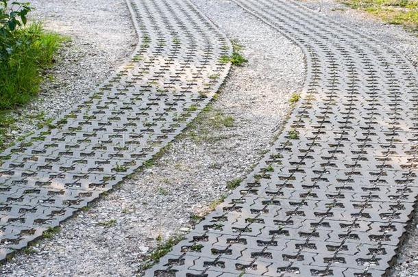 弧形的马路关于沙砾和草地格子石头