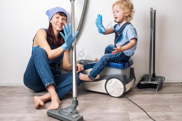 妈妈和女儿采用蓝色斜纹粗棉布工装裤清洁在家和空泡