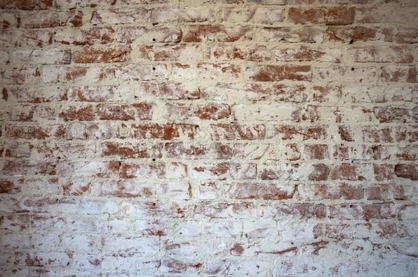 风化的玷污的红色的砖墙背景质地剥皮熟石膏