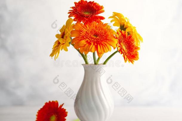 美丽的花束关于红色的和黄色的花采用白色的装饰瓶向<strong>求爱</strong>