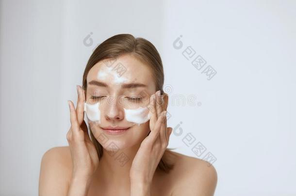 面容皮关心.女人应用面部的清洁剂向面容特写镜头