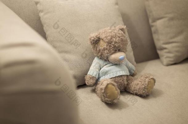 孤独的妇女连衫衬裤熊是（be的三单形式向指已提到的人棕色的沙发.孤独的木偶