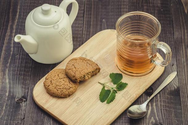 白色的茶壶,甜饼干和一半的玻璃薄荷茶水/白色的茶壶,烹调