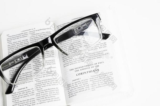 白色的口袋圣经和阅读眼镜