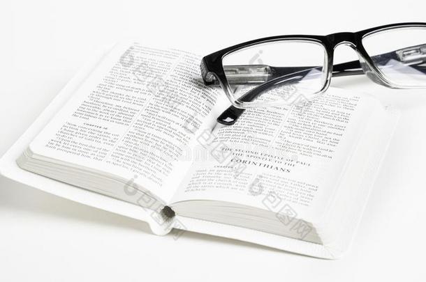 白色的口袋圣经和阅读眼镜
