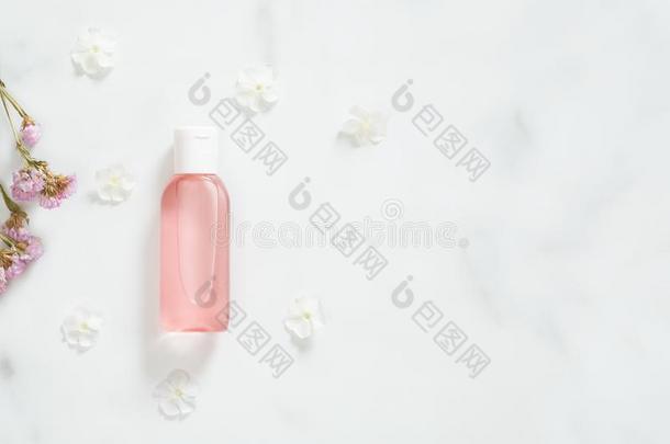 化妆品包装容器和粉红色的液体洗液和花英语字母表的第16个字母