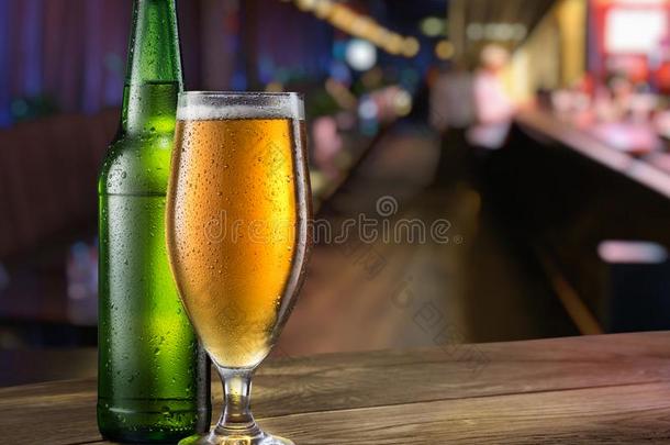 玻璃关于光啤酒和绿色的啤酒瓶子向指已提到的人条柜台