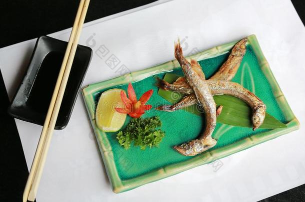 烤的鱼香鱼科的小海鱼或希沙莫向绿色的正方形盘子
