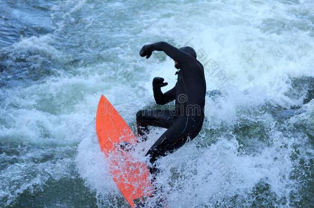 男人采用黑的潜水服是（be的三单形式surf采用g采用波