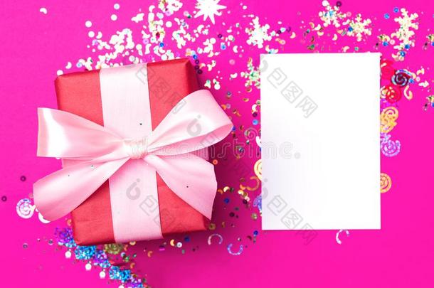 红色的赠品盒和粉红色的弓向粉红色的背景和闪烁.胡里节