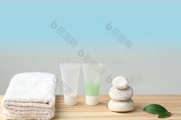 一折叠的白色的毛巾,化妆品瓶子,白色的圆形的石头向一