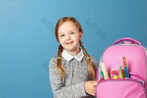 特写镜头肖像关于小的女孩school女孩和背包向蓝色