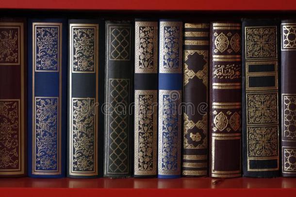 浓的镀金的书使关于红色的和黑的精装书有菱形花格的麻或棉织物.