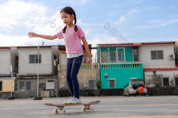 亚洲人小的女孩演奏滑板选择集中浅的深度