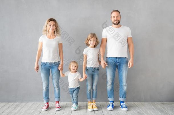 幸福的家庭起立反对灰色的背景