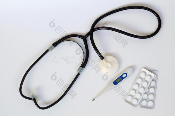 医学的听诊器和药丸和温度计向白色的后台