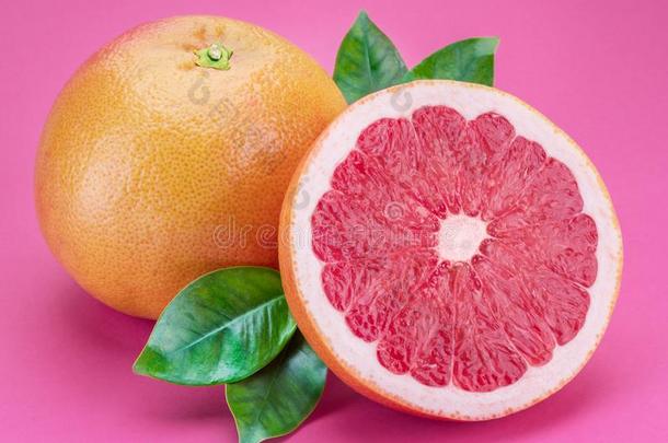 葡萄柚和葡萄柚部分隔离的向粉红色的背景