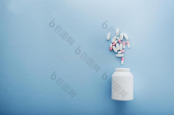 制药的医学药丸和瓶子向蓝色背景