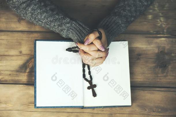 女人手十字架向书